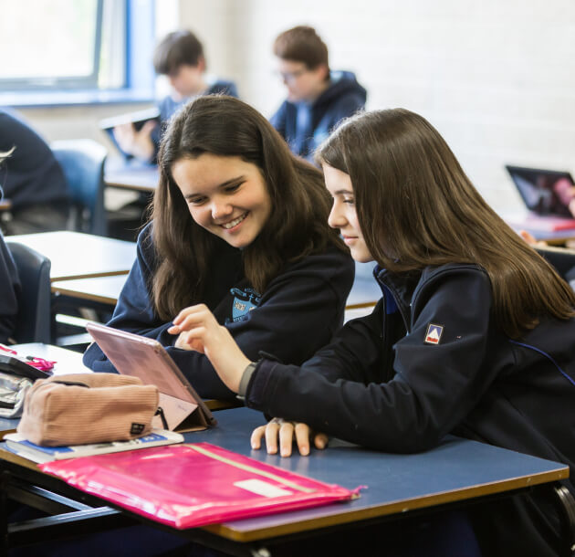 girls in the classroom looking at an iPad