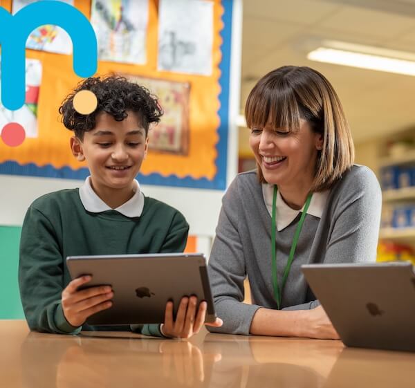 a teacher and student looking at a tablet device