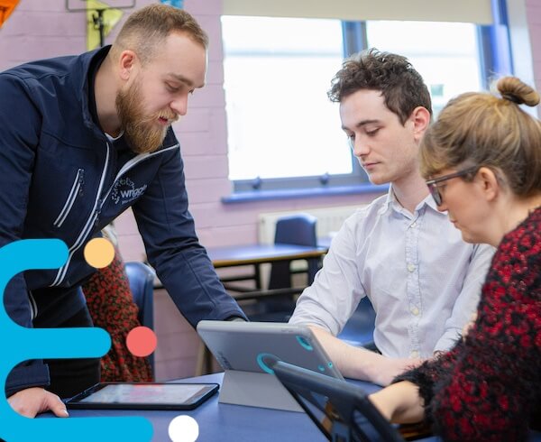 a teacher speaking with other teachers in the classroom