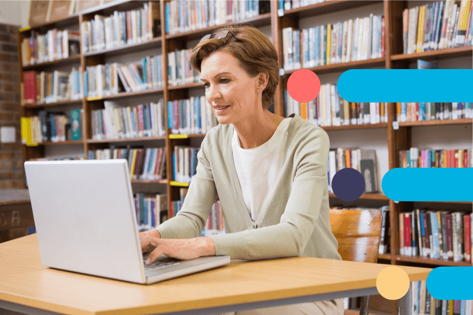 A woman working on a laptop in the library