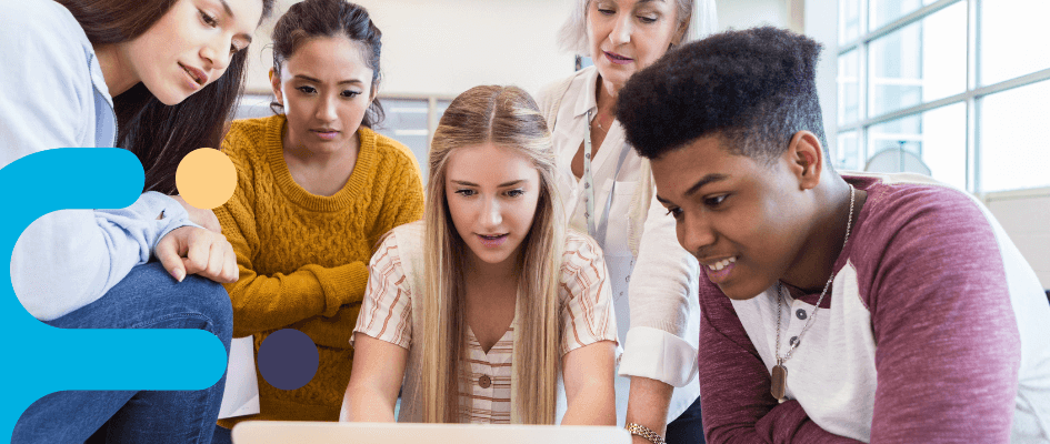 students and a teacher looking at a laptop