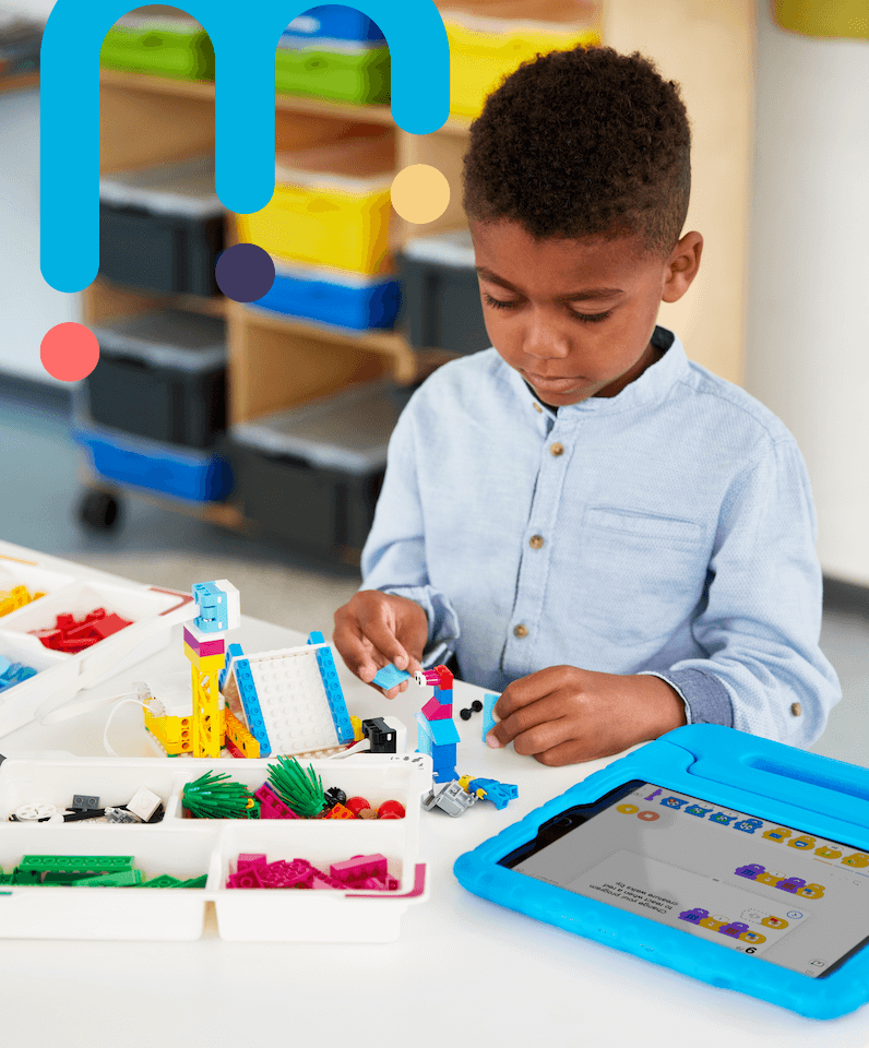 School child using lego and a tablet device