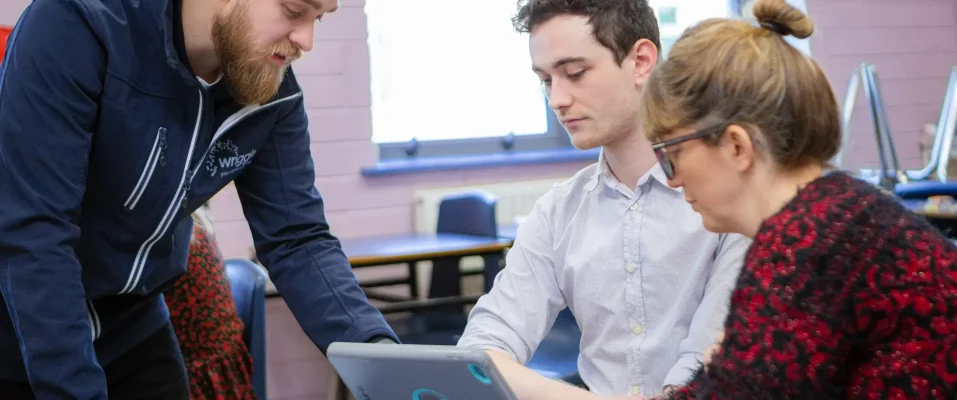 A teacher training two other teachers in the use of iPad in the classroom