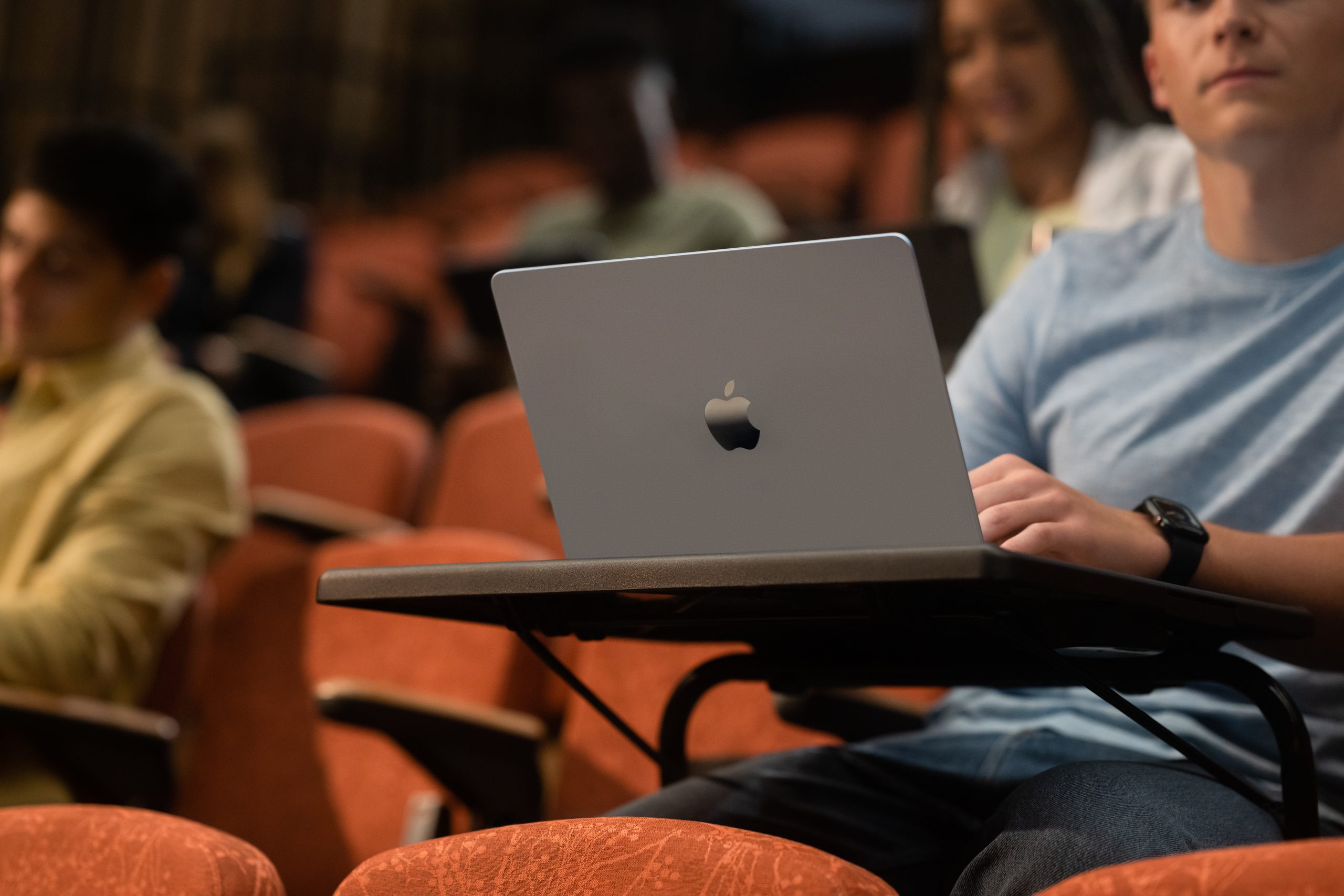 A student using Mac in a college lecture theatre