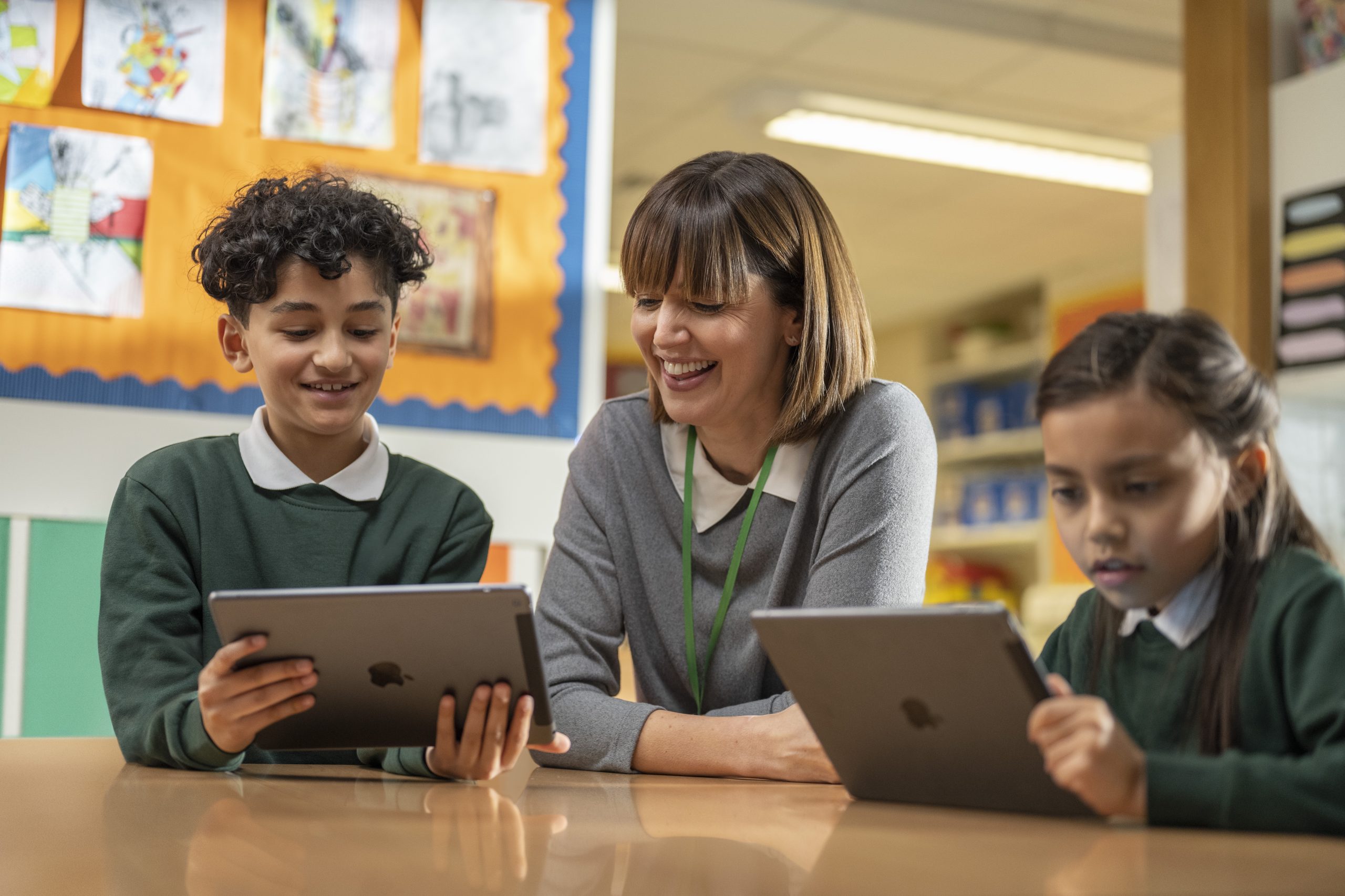 a teacher and students using ipads in class